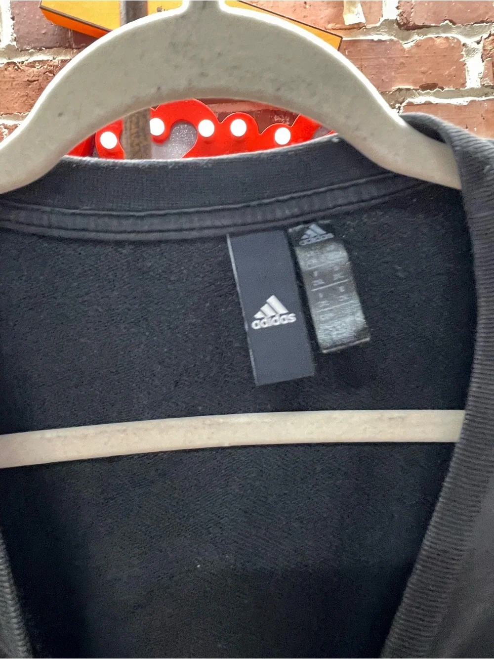 black Adidas crewneck fleece sweatshirt featuring a large white performance